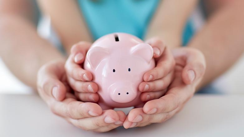 Parent and child holding a piggy bank