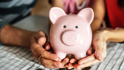 Piggy bank being held by family