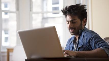 Man wearing denim short on a laptop