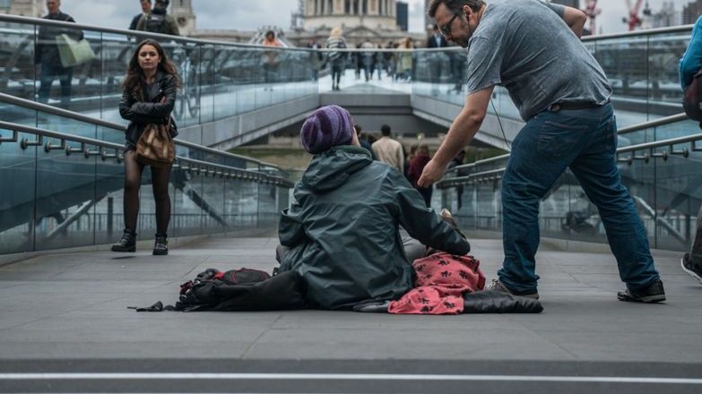 Person giving homeless person in london some change