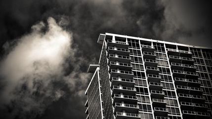 Black and white photo of a high rise bulidng with smokey sky
