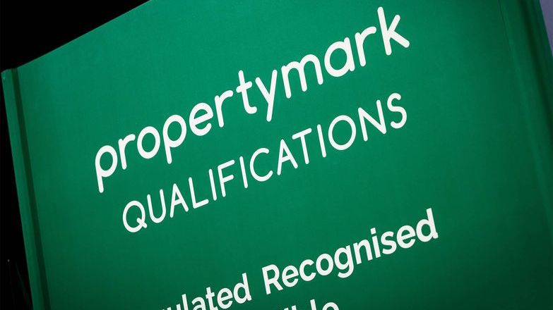 Propertymark Qualifications logo displayed on an event stand