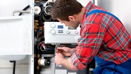 Heating engineer servicing a boiler