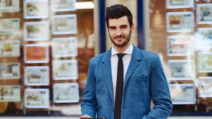 Estate agent stood outside of branch